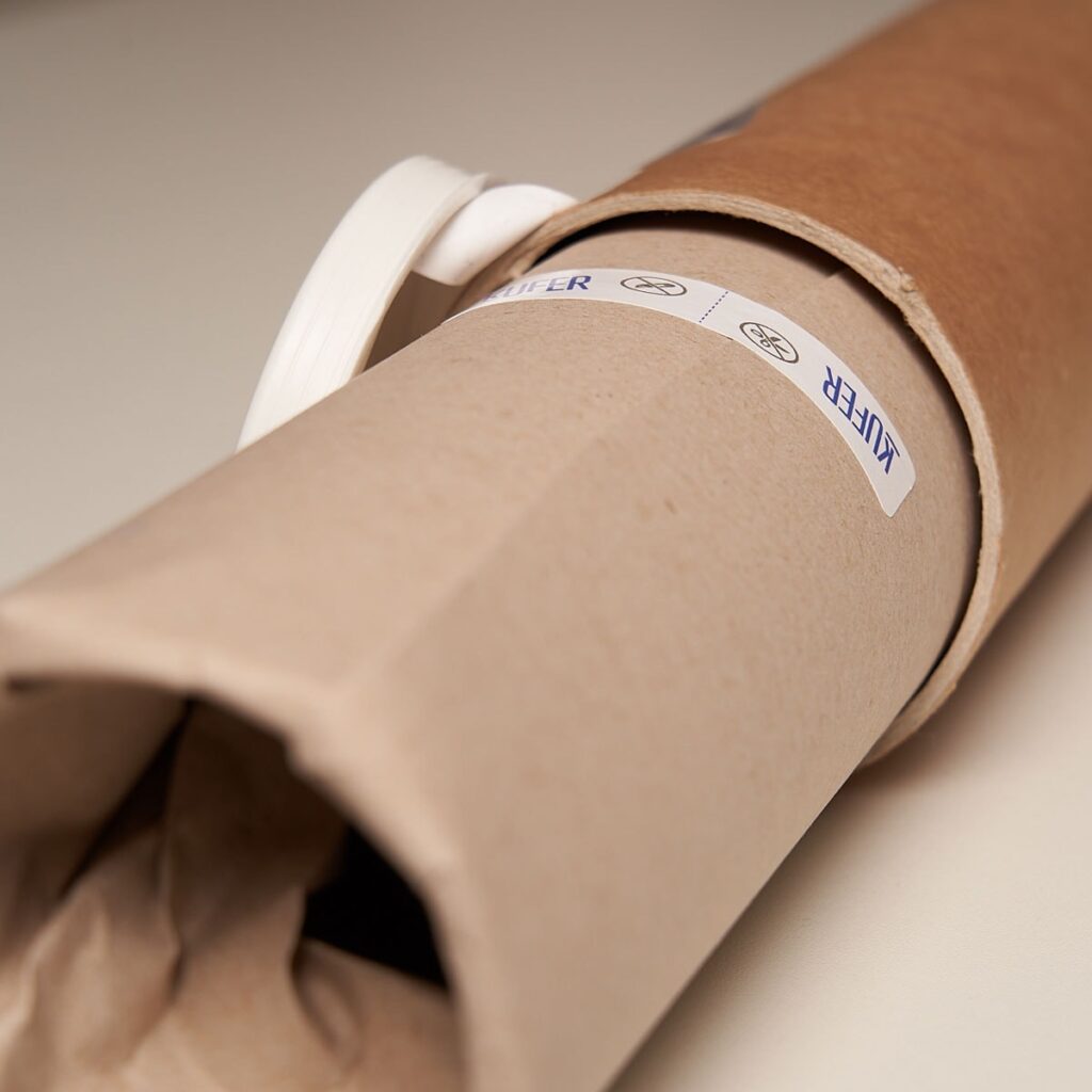 photo - a tube with a poster wrapped in paper with stickers from kufer.pl
